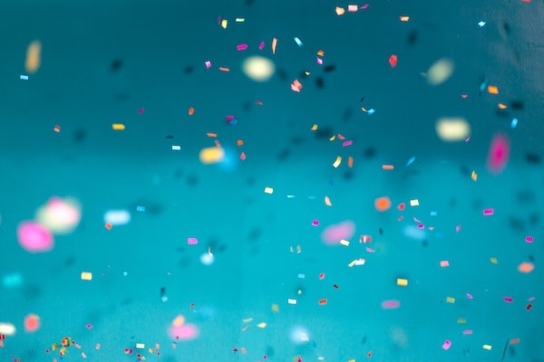 Colored confetti flying in a blue background
